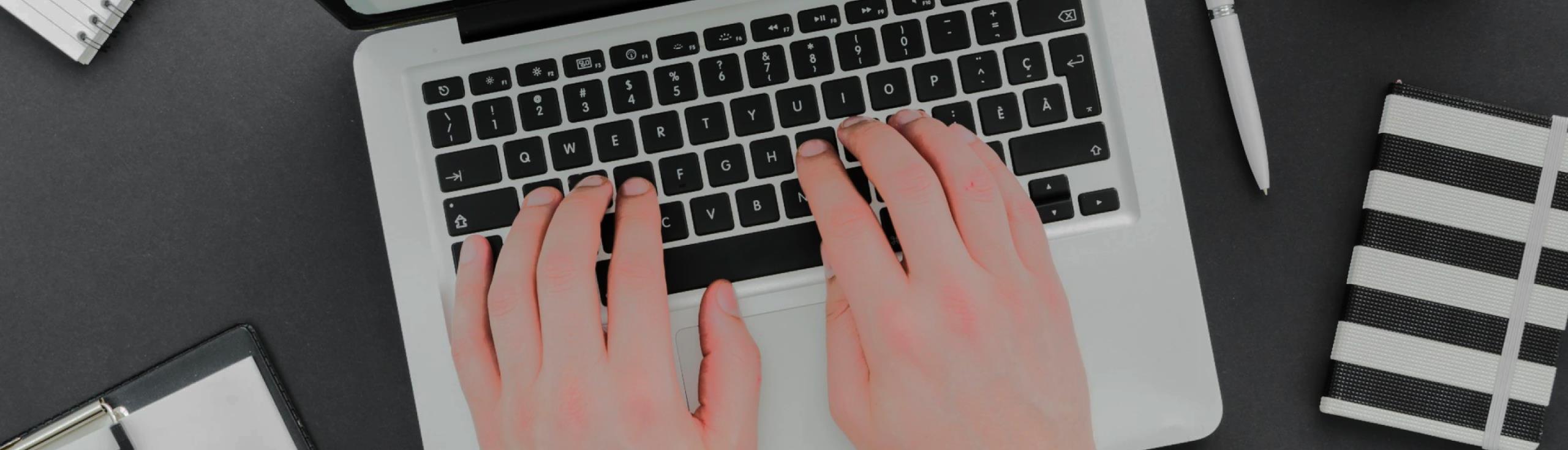 Hands typing on a laptop.